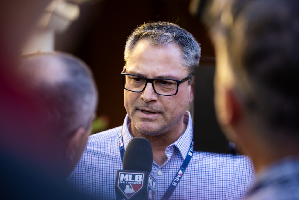 a man wearing glasses talking to a microphone